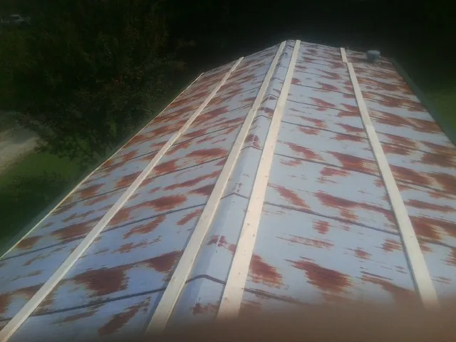 Rusted metal roof panels with new wood purlins before replacement — Storm Damage Roof Repair in Wisconsin Rapids by Roofing Brothers