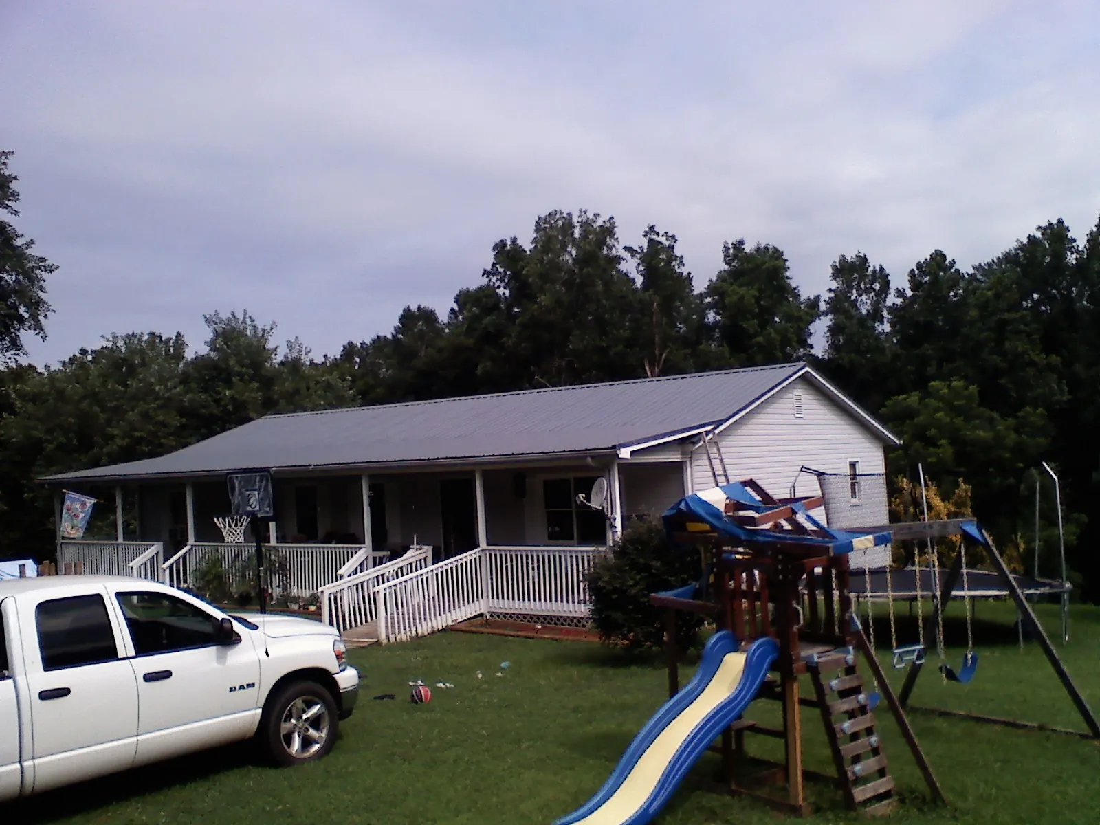 Dark metal roof on a country home with a full length front porch in Wisconsin Rapids