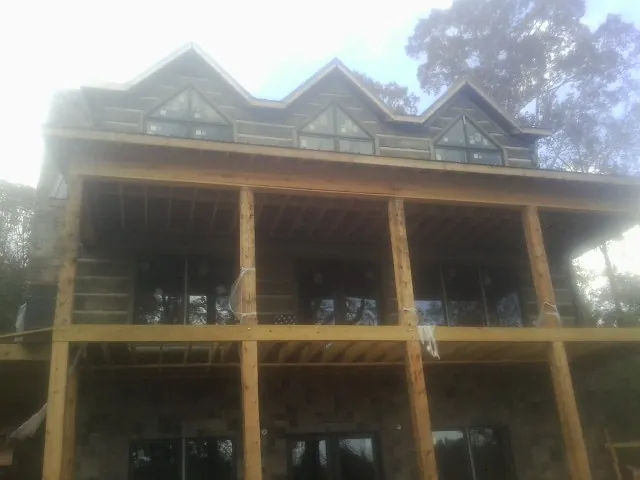 Dormers and porch framing on a large log home under construction — Roof Coating work by our crew in Wisconsin Rapids