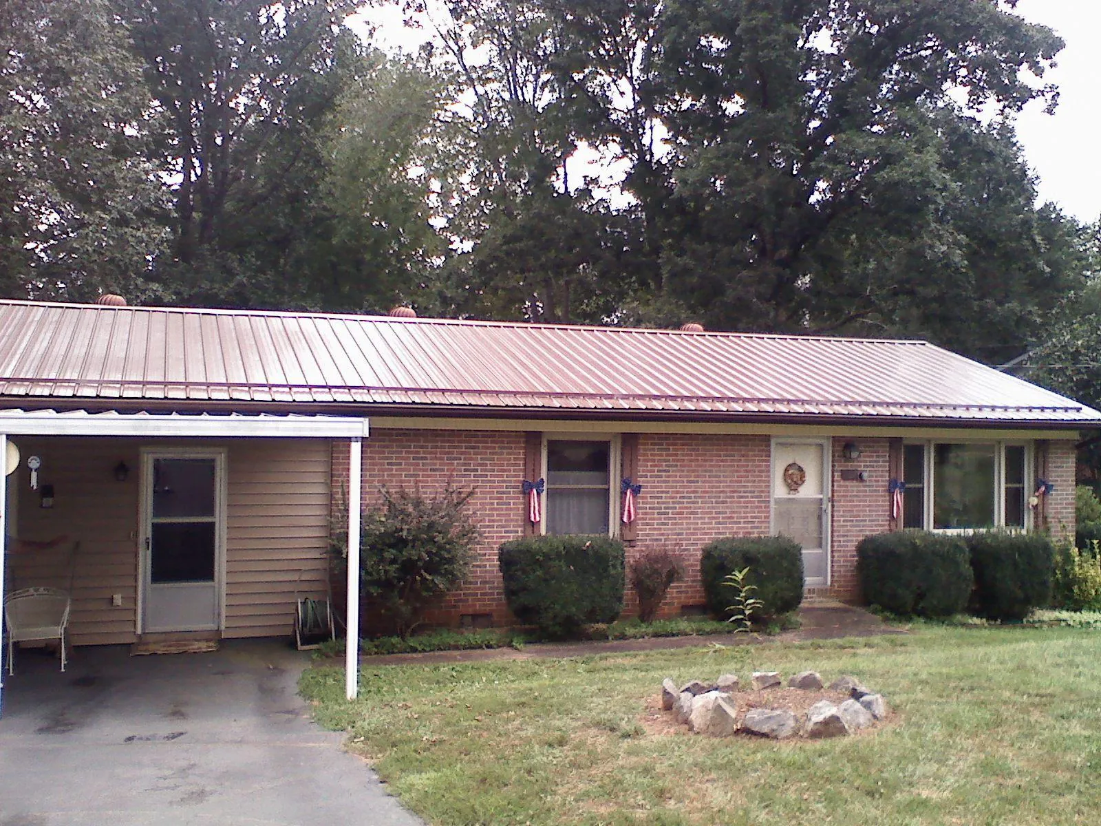 Bronze metal roof and carport on a brick ranch home — Roof Repair work by our crew in Wisconsin Rapids